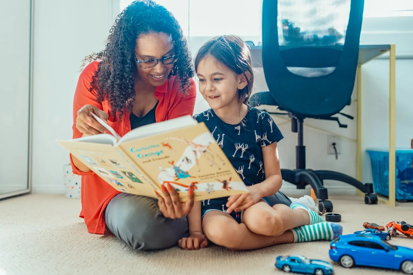 Mother and daughter bonding over reading at home, creating joyful family moments.